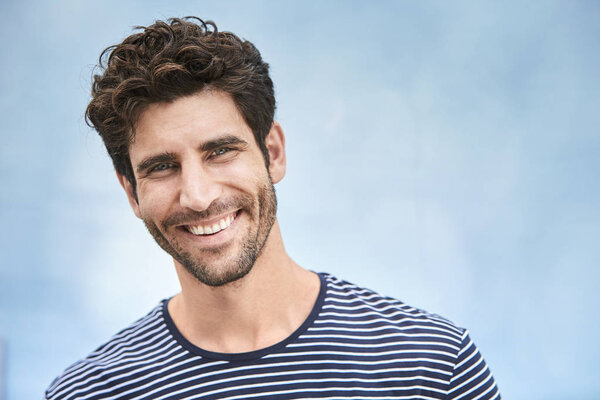 Портрет молодого парня в полосатом топе, улыбающегося
