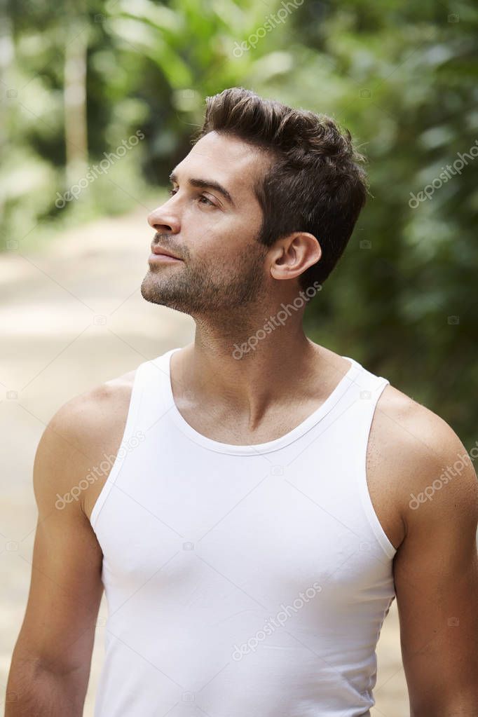 Handsome guy in white vest, looking away