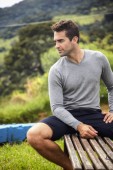 Handsome man in shorts, sitting on bench
