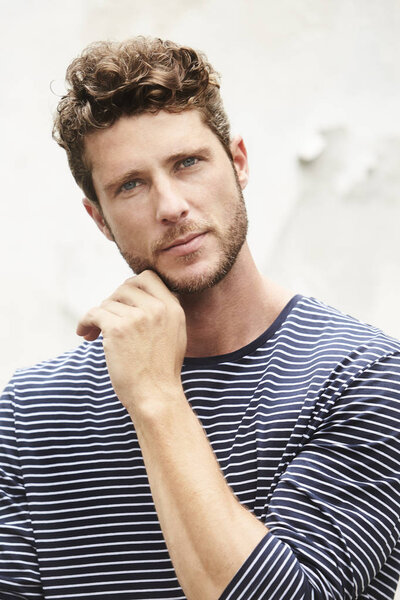 Thoughtful young man in striped top, portrait