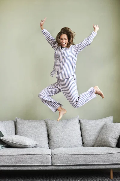 Mulher Pijama Pulando Alegria Sofá — Fotografia de Stock