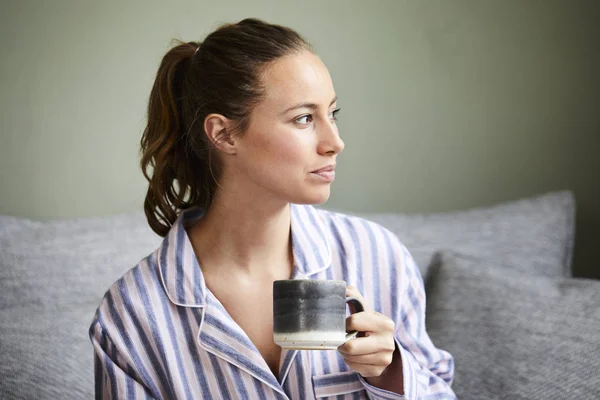 朝にコーヒーを飲んだパジャマの女の子 目をそらす — ストック写真