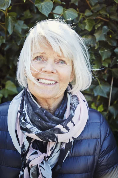 Happy senior woman in scarf and warm jacket, portrait