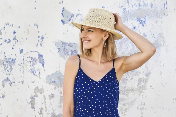 Saman şapka gülümseyen genç kadın, uzağa bakıyor