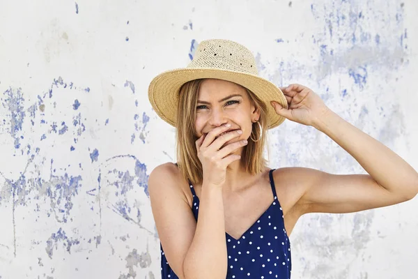 Güzel genç sarışın kadın gizleme gülümseme arkasında el, portre