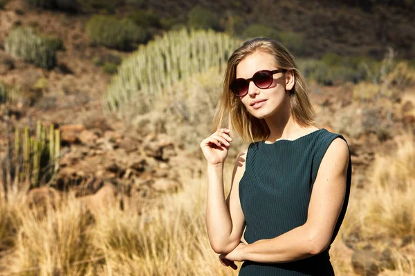 Güneş gözlüğü genç sarışın kadın, uzak çöl bakıyor