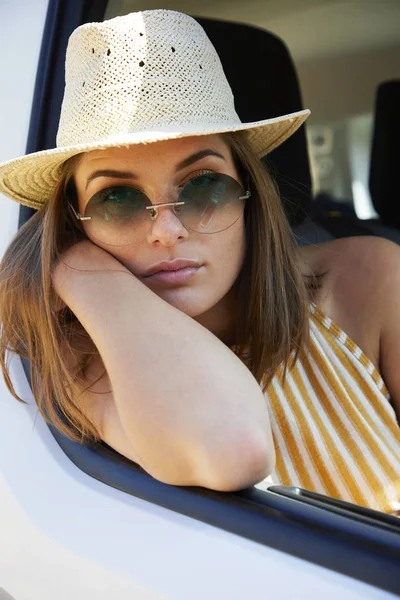 Güneş şapkalı şık esmer, arabada eğilme, portre