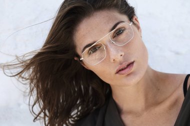 Windswept genç esmer kadın kameraya bakıyor