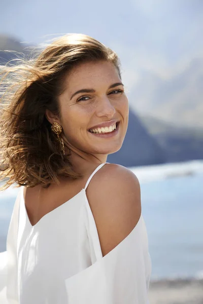 Portrait of smiling young woman by sea