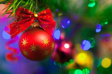 Aydınlatma ile Noel ağacında Noel oyuncakları. Bulanık ışıklı arka plan ve yumuşak odak ile bokeh parlak canlı baubles. Mutlu Noeller ve Mutlu Yıllar.