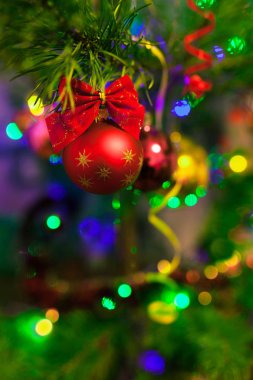 Aydınlatma ile Noel ağacında Noel oyuncakları. Bulanık ışıklı arka plan ve yumuşak odak ile bokeh parlak canlı baubles. Mutlu Noeller ve Mutlu Yıllar.