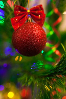 Aydınlatma ile Noel ağacında Noel oyuncakları. Bulanık ışıklı arka plan ve yumuşak odak ile bokeh parlak canlı baubles. Mutlu Noeller ve Mutlu Yıllar.