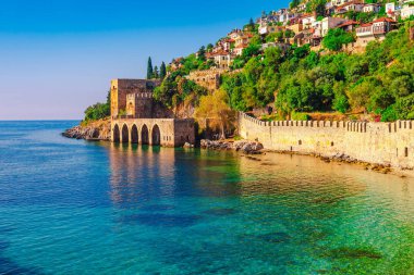 Alanya yarımadasındaki Kızıl Kule kulesi yakınındaki antik tersane manzarası, Antalya ilçesi, Türkiye, Asya. Yüksek dağlar ile ünlü turistik yer. Eski eski Kale'nin bir parçası.