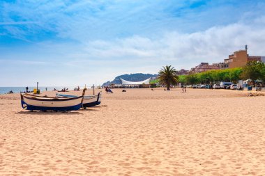 Beach at seaside in Calella in Catalonia, Spain near Barcelona. Scenic old town with sand beach and clear blue water. Famous tourist destination in Costa Brava, perfect place for holiday and vacation clipart