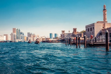 Geleneksel tekneler ve iskeleler ile Dubai Creek silüeti görünümü. Güneşli bir yaz günü. Bae ünlü turistik yer.