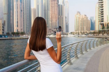 Mutlu güzel tanınmayacak halde turist kadın moda yaz beyaz elbise Birleşik Arap Emirlikleri Dubai Marina zevk. Lüks ve konforlu turizm sezonunda Birleşik Arap Emirlikleri.