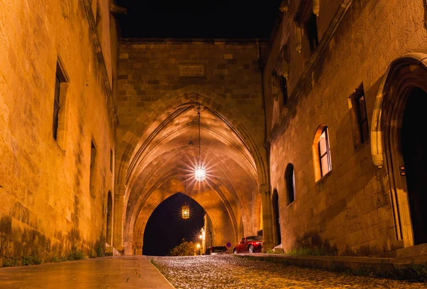 Night photo of ancient street of the Knights in Rhodes city on Rhodes island, Dodecanese, Greece. Stone walls and bright night lights. Famous tourist destination in South Europe