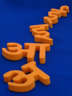 Mavi bez arkaplan üzerinde Hint Hintçe dilinin 4 alfabesini gösteren bir resim, harflere yüksek bir karşıtlık verir