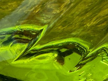 Üzerinde dalgalı bir çizgi olan yeşil bir nesne..