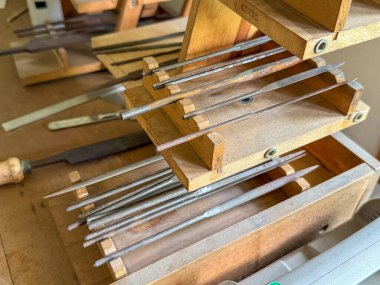 İçinde keskin nesneler olan ahşap bir kutu. Nesneler birbirlerine dokunmadıkları bir şekilde sıralanır. Kutu masanın üstünde.