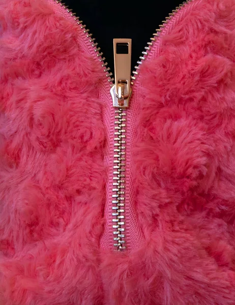 Zipper in furry fabric. Background. Open and close metal zipper sewn in metal fabric with black tab.