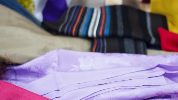 Pile of different colored clothes, closeup. Colorful background for fashion theme