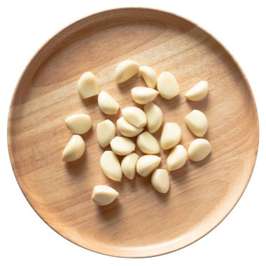 Beyaz arka planda izole yuvarlak ahşap plaka üzerinde sarımsaklı karanfil