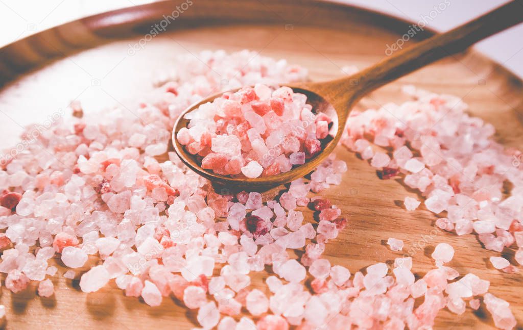 Pink salt from Bolivian in spoon on wooden plate
