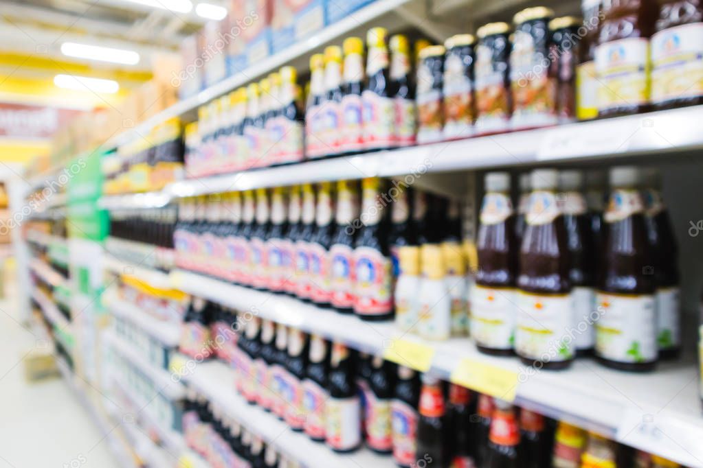 Blurred variety of sauces, soy sauce, fish sauce on shelves