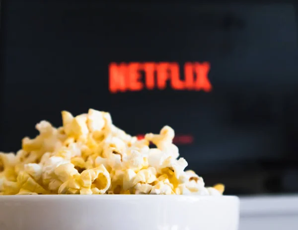 Chiangmai, thailand - 4. Juli 2019- popcorn bowl und netflix logo auf smart tv — Stockfoto