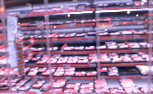 Blurred modern retail supermarket aisle shelves chilled meat zone