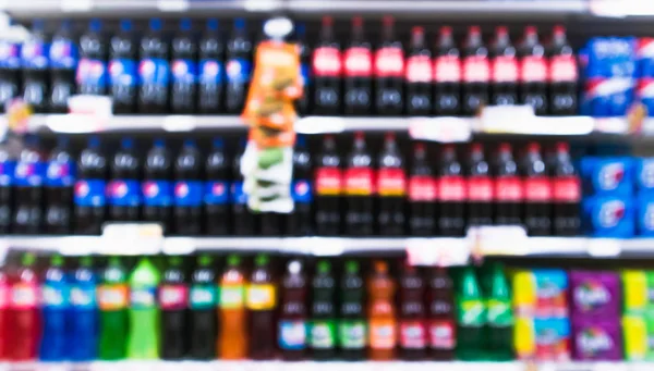 Variedad borrosa de refrescos en los estantes del supermercado de la tienda de comestibles — Foto de Stock