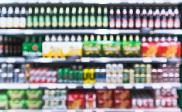 Variedad borrosa de bebida de cerveza y alcohol en los estantes del supermercado de la tienda de comestibles — Foto de Stock