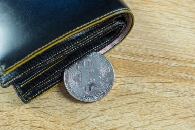 Bitcoin dijital para yerine gerçek para, bit-sikke ile deri cüzdan veya çantanızda ahşap çalışma masa, sanal cryptocurrency para iş kavramı fikri üzerinde.
