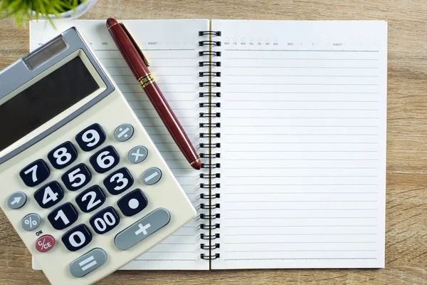 Dolma kalem veya tükenmez kalem defter kağıt ve ahşap çalışma masa kopya alanı, office Danışma konsept fikir ile hesap makinesi ile. Üstten Görünüm.
