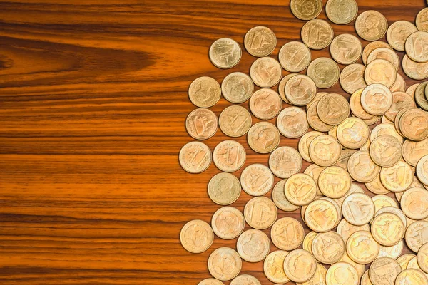 Ahşap çalışma masa, iş ve finans kavramı fikri üzerine sikke yığını.