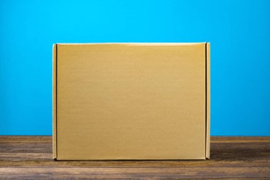 Kopya alanı ile koyu ahşap masa üzerinde sahte için kahverengi karton kutu boş kapandı.