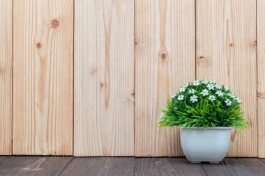 Küçük dekoratif ağaç ve çiçek buketi kopya alanı ile ahşap masa üzerinde beyaz cam aranjman. arka plan.