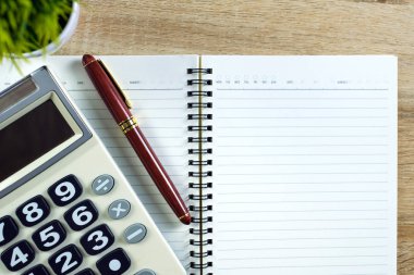 Dolma kalem veya tükenmez kalem defter kağıt ve ahşap çalışma masa kopya alanı, office Danışma konsept fikir ile hesap makinesi ile. Üstten Görünüm.