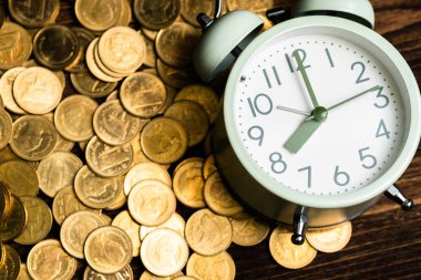 Çalar saat ve karanlık bir odada, tasarruf para kavramı, bankacılık ve iş kavramı fikri çalışma tablo para yığınları.