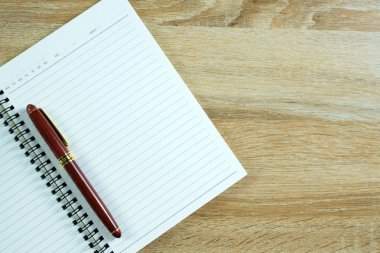 Dolma kalem veya tükenmez kalem defter kağıt üzerinde kopya alanı, office Danışma konsept fikir ile ahşap çalışma masa ile. Üstten Görünüm.