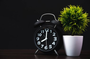 Küçük dekoratif ağaç ve ahşap masa için kopya alanı ile karanlık odada vintage çalar saat ile beyaz vazoda çiçek buketi metin ekleyin.