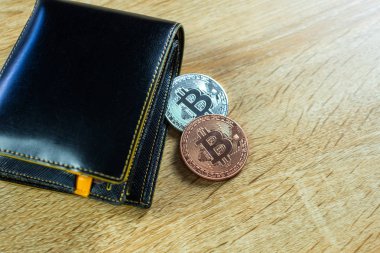 Bitcoin dijital para yerine gerçek para, bit-sikke ile deri cüzdan veya çantanızda ahşap çalışma masa, sanal cryptocurrency para iş kavramı fikri üzerinde.