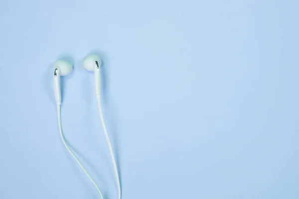 Weiße Kopfhörer Oder Ohrhörer Smalltalk Auf Süßblauem Pastellpapier Draufsicht Textur — Stockfoto