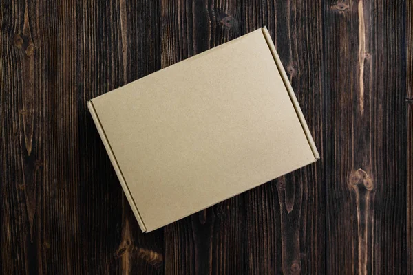 Boş paket kahverengi karton kutu veya tepsi görünümünü ahşap zemin üzerine alay için koymak ürün top