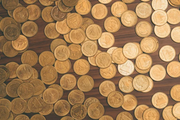 Ahşap çalışma masa, iş ve finans kavramı fikri üzerine sikke yığını.