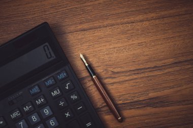 Dolma kalem veya tükenmez kalem ile ahşap çalışma masa kopya alanı, office Danışma konsept fikir ile hesap makinesi.