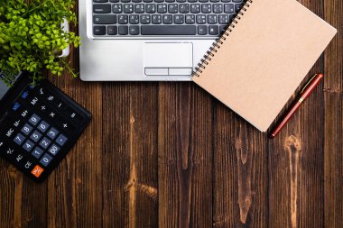 Ofis, banka donatımı veya office çalışma temel araçları veya öğeleri çalışma alanı, dizüstü bilgisayar dizüstü bilgisayar hesap makinası ve çalar saat ahşap masa üzerinde en iyi görünüm için kopya alanı ile eklemek metin ve mesaj.