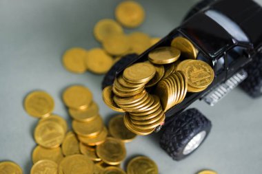 Minyatür araba kamyonet siyah renkli sikke tasarruf para ve iş ekonomi kavramı bankacılık kopya alanı ile gri arka plan üzerinde yığınları ile.