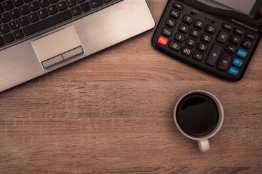 Dizüstü bilgisayar ya da defter, hesap makinesi ve kahve çalışma tablosu veya Danışma, çalışma alanı kopyasını alan içeren görünüm üst. Vintage sesi.